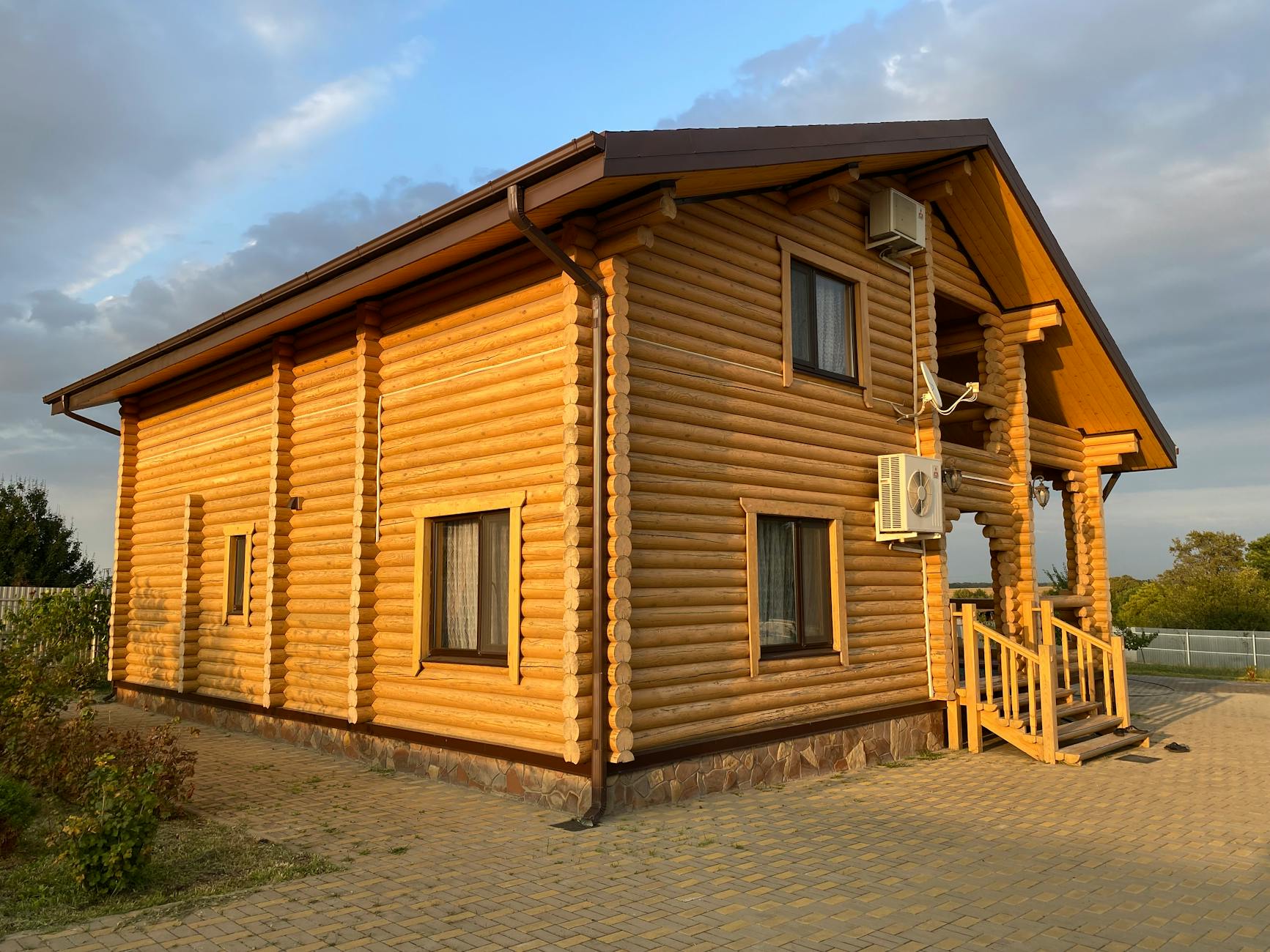 Drewniany dom z bali na tle bezchmurnego, błękitnego mazurskiego nieba