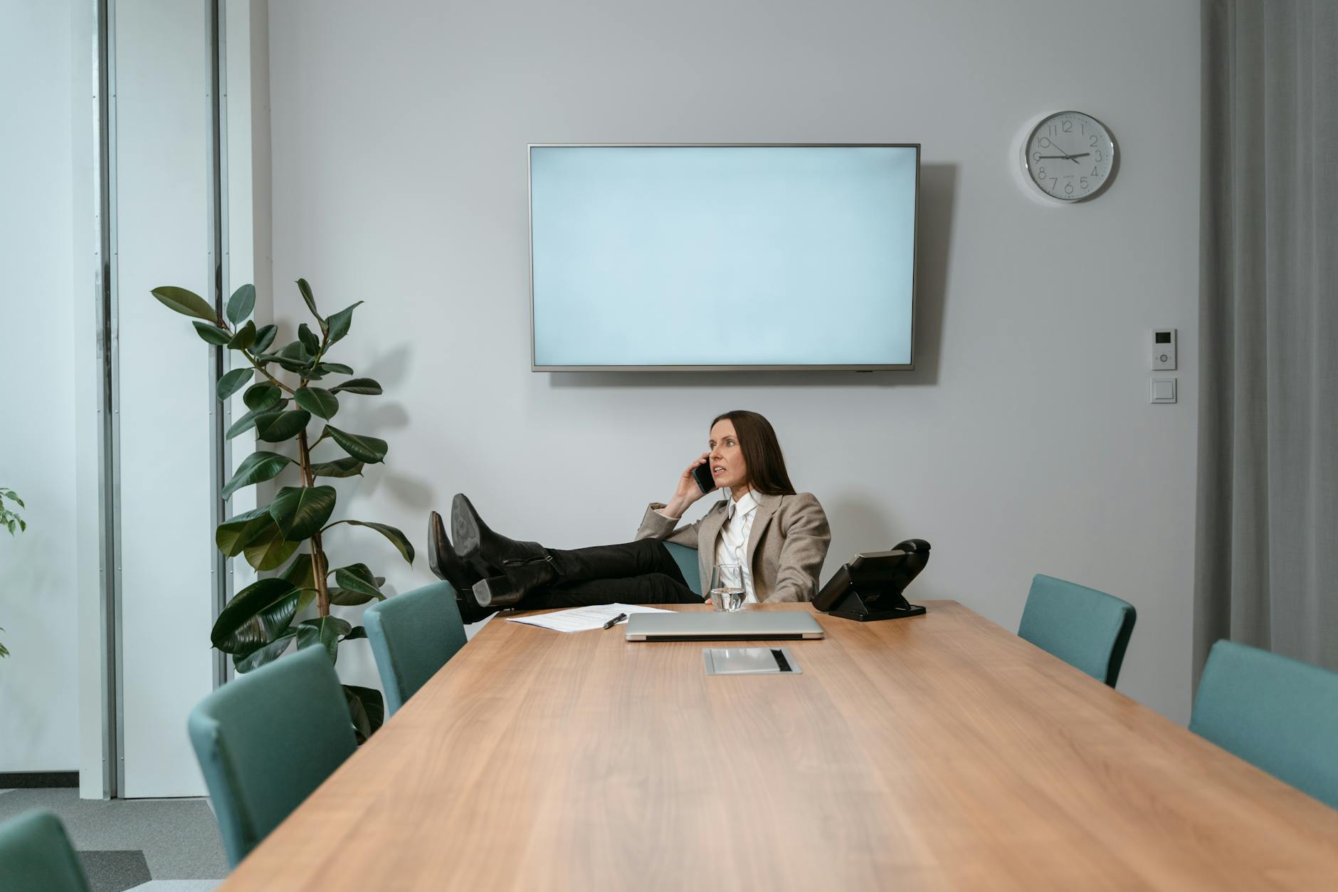 Kobieta w biurze odpoczywa, rozmawiając przez telefon